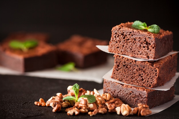 Chocolate brownie square pieces in stack with walnuts, mint leaves and ...