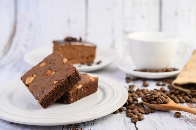 Chocolate brownies  on a white  plate and coffee  beans on a 