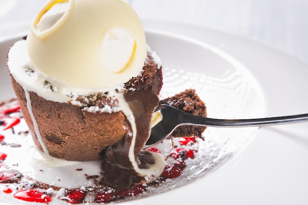 Premium Photo Chocolate Lava Cake Molten With Melting Ice Cream Chocolate With Spoon On Plate