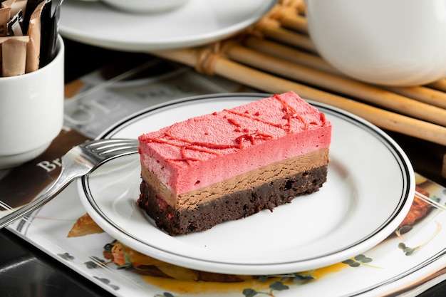 Chocolate and strawberry cheesecake plate garnished with strawberry syrup Free Photo
