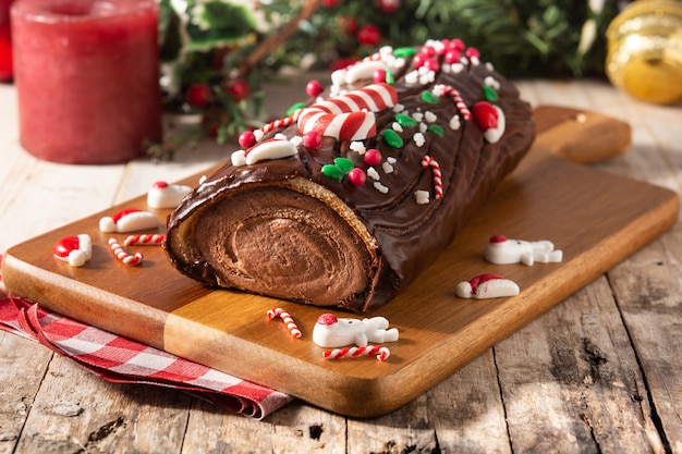 Premium Photo | Chocolate yule log christmas cake on wooden table