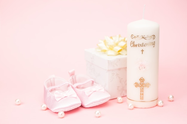 Premium Photo | Christening candle with pink baby booties ...