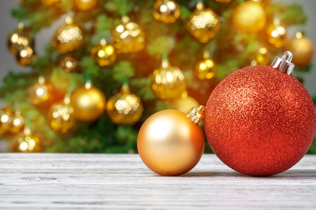 Christmas Baubles On Wooden Table Against Decorated Christmas Tree