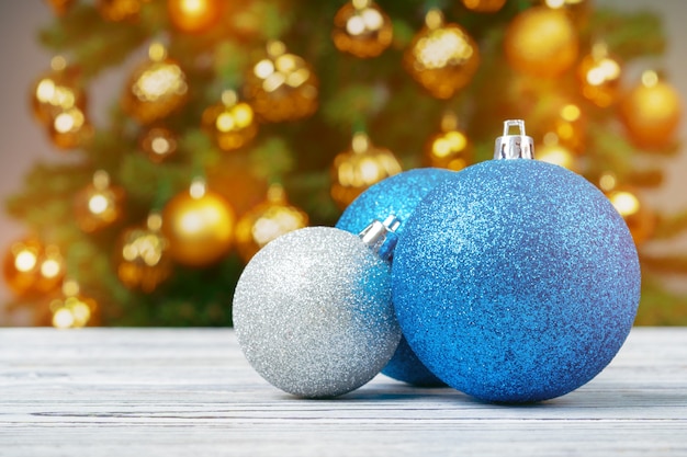 Christmas Baubles On Wooden Table Against Decorated Christmas Tree