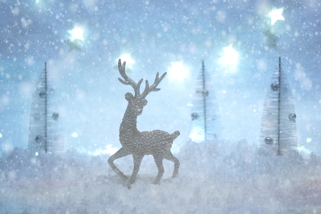 雪と光の冬の妖精の森でおもちゃの鹿とクリスマスカード プレミアム写真