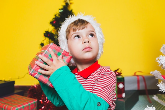 Free Photo | Christmas concepto with with boy shaking present box