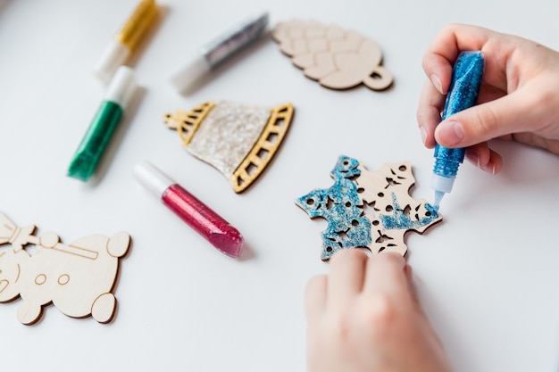 クリスマスプレゼント 手作りの木製おもちゃ クリスマスの飾り クリスマスの装飾飾りを作る小さな子供 プレミアム写真