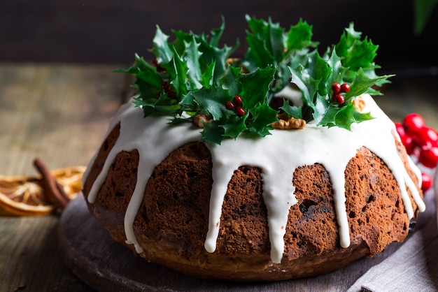 Christmas homebaked dark chocolate bundt cake decorated with white icing and holly berry ...