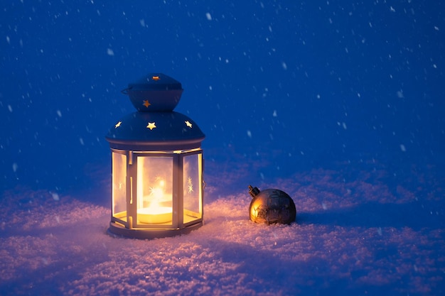 Premium Photo | Christmas lantern and toy in the snow. lantern and toy