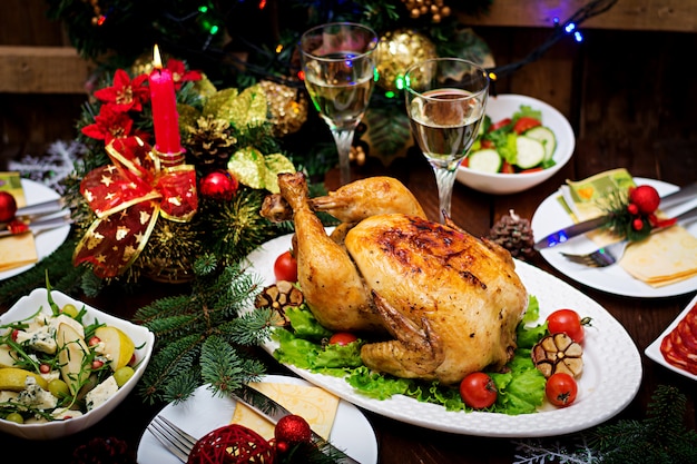 Christmas table served with a turkey, decorated with bright tinsel and ...