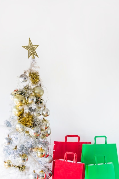 Free Photo | Christmas tree near shopping bags