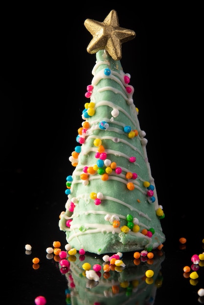 黒の背景にクリスマスツリーの形をしたキャンディー 選択的な焦点 プレミアム写真