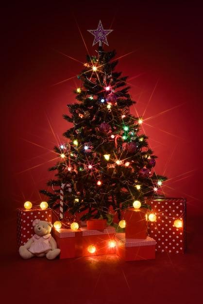 赤の背景に贈り物クリスマスツリー 無料の写真