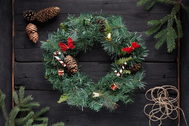 Premium Photo | Christmas wreath on black wooden background