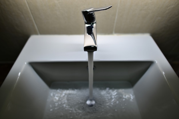 Download Free Chrome Plated Faucet With Running Water In The Bathroom Premium Use our free logo maker to create a logo and build your brand. Put your logo on business cards, promotional products, or your website for brand visibility.