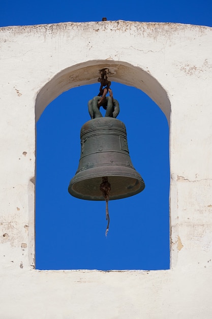 Premium Photo | Church bell on a white bell tower against a blue clear sky