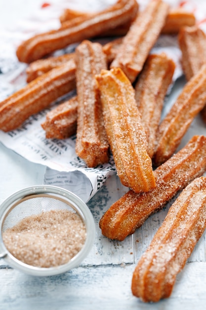 Premium Photo | Churros sprinkled with sugar and cinnamon on white ...