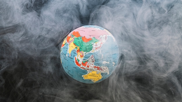 Circular globe surrounded by smoke Free Photo
