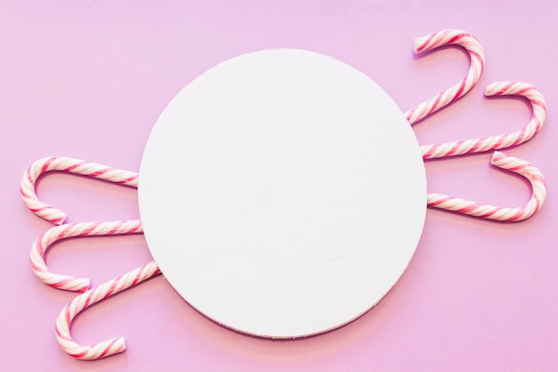 Circular white blank frame with xmas candy canes design on pink background Free Photo Circular white blank frame with xmas candy canes design on pink background Free Photo