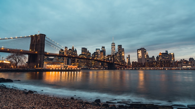 ブルックリン橋とマンハッタンニューヨーク アメリカ合衆国の建物の街並みの夜景 プレミアム写真