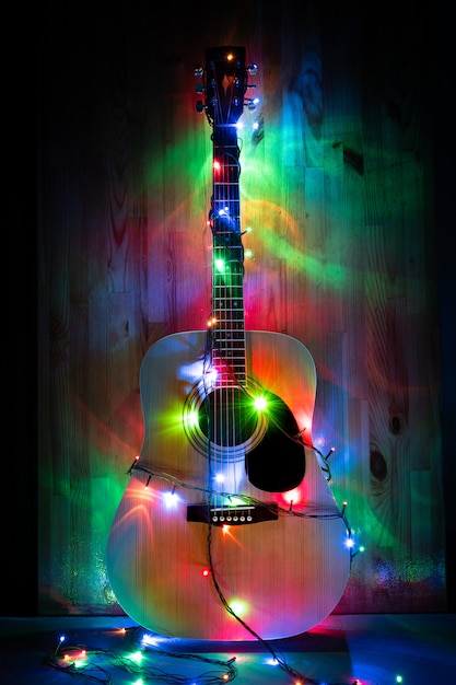 Premium Photo | Classic acoustic guitar in christmas holiday lights in ...