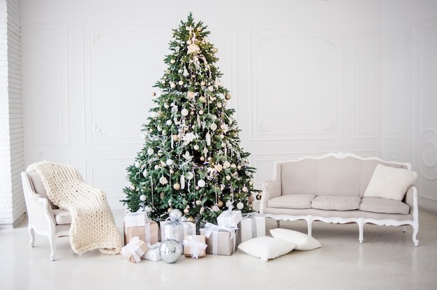 古典的なクリスマス新年はインテリアルーム新年ツリーを装飾されています 金の装飾とクリスマスツリー モダンな白いクラシックスタイルのインテリアデザイン プレミアム写真