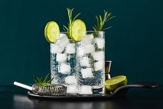 Download Premium Photo Classic Gin And Tonic Cocktail With Rosemary Sprigs In Tall Glasses On A Table With Bar Accessories
