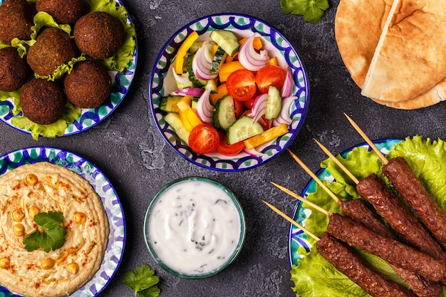 Premium Photo | Classic kebabs, falafel and hummus on the plates.