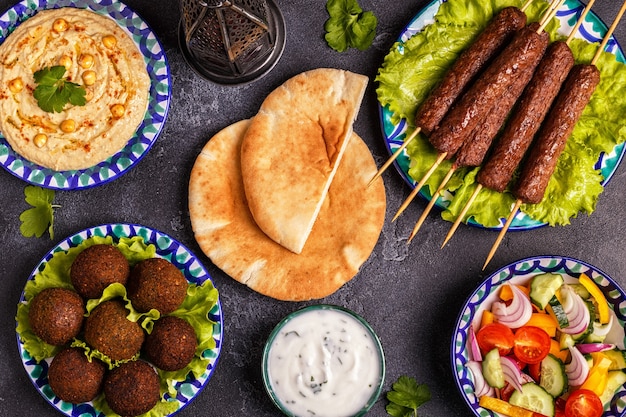 Premium Photo | Classic kebabs, falafel and hummus on the plates.