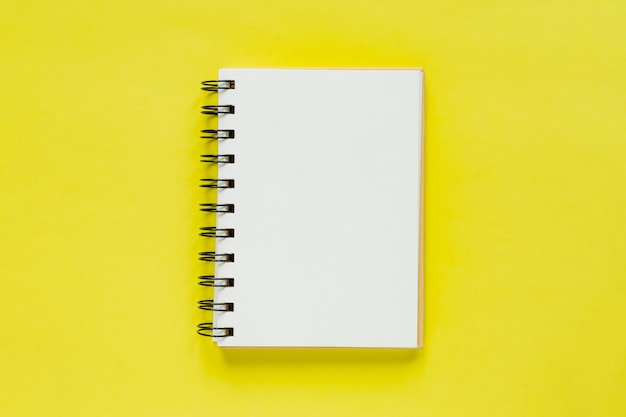 Premium Photo Clean Note Book For Goals And Resolutions Mockup For Your Design Spiral Note Book On Yellow Background