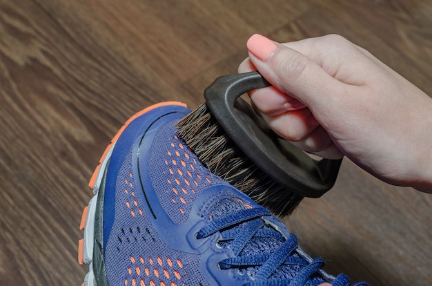 Premium Photo Cleans Sports Shoes Woman Cleans Shoes With A Brush