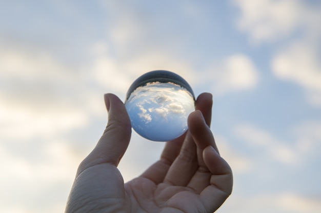 Premium Photo | A clear crystal ball is reflecting the scene behind in ...