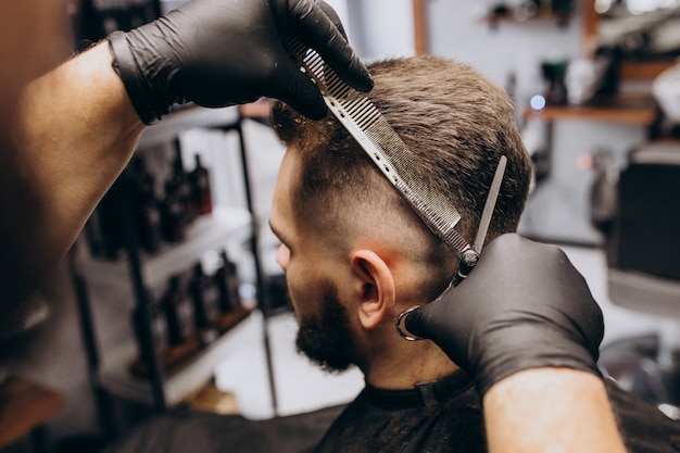 Client doing hair cut at a barber shop salon | Free Photo