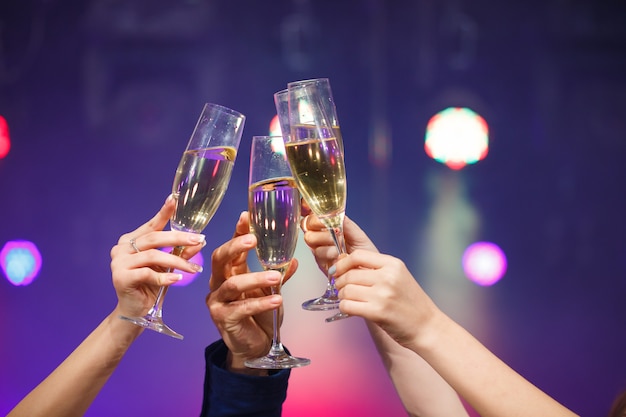 Premium Photo Clinking Glasses Of Champagne In Hands On Bright Lights Background