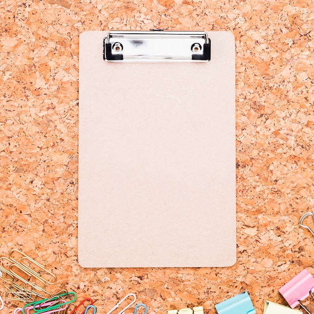 Free Photo | Clipboard and multicolored paper clips placed on cork board
