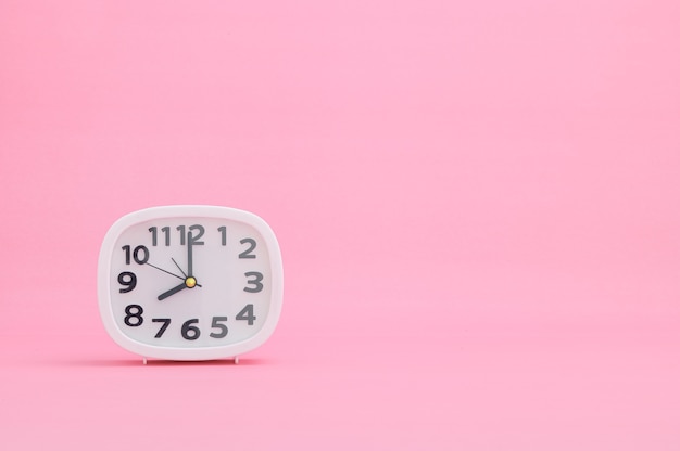 Premium Photo | Clock showing time on a pink background