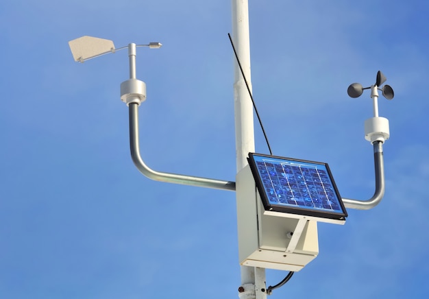 Premium Photo | Close on an anemometer with solar panel on blue sky