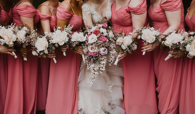 Free Photo | Close shot of a bride with her bridesmaids holding flowers