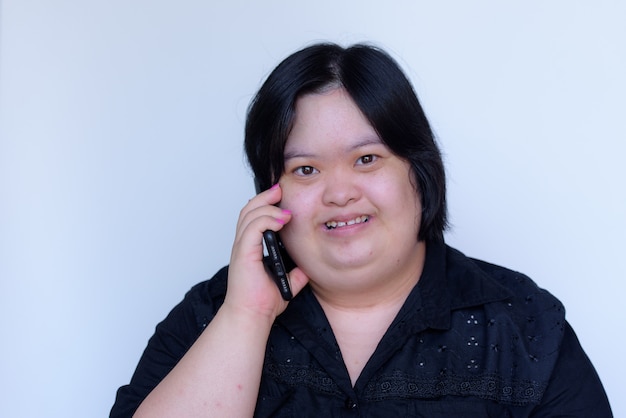 Premium Photo Close Up Of An Asian Girl With A Disability Down Syndrome Children Talking On The Phone And Smiling Happy On A White Background