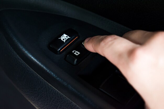クローズアップ アジアの手がボタンを押して車のドアをロックする プレミアム写真