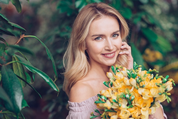 Free Photo | Close-up of blonde young woman with yellow flower bouquet