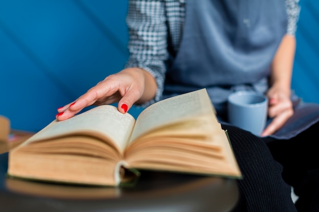 Free Photo | Close-up of book and woman holding mug