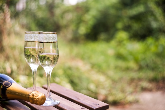 Free Photo Close Up Of Champagne Glasses On Wooden Table At Outdoors