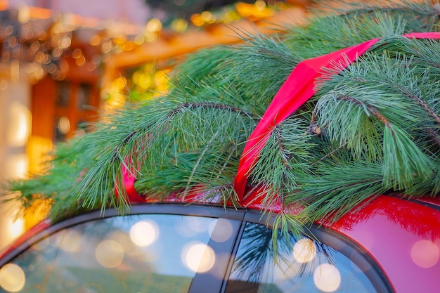 Premium Photo | Close-up christmas tree tied with a red ribbon on the ...