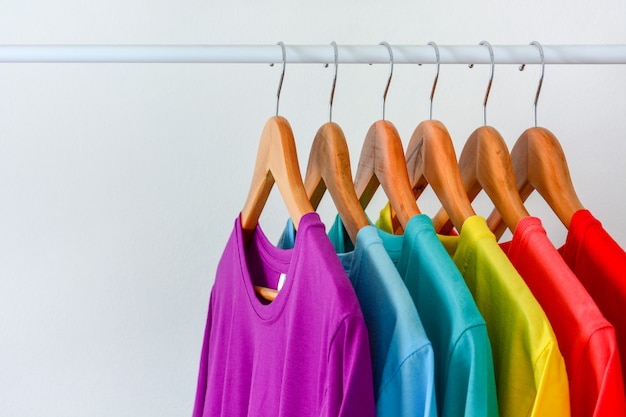 Premium Photo | Close up collection of colorful rainbow t-shirts hanging on  wooden clothes hanger in closet