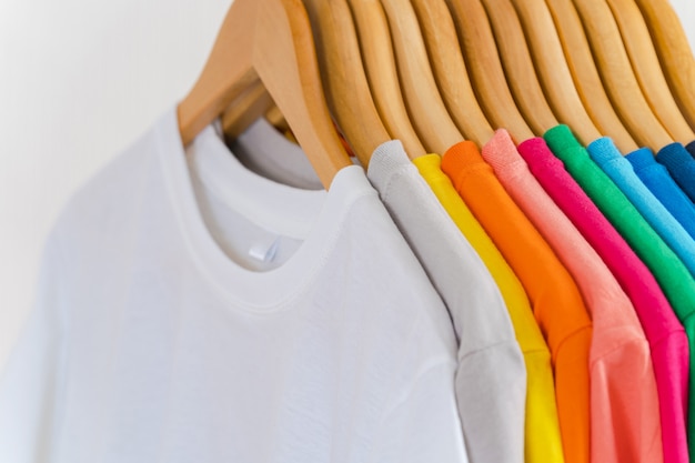 Premium Photo | Close up of colorful t-shirts on hangers, apparel ...