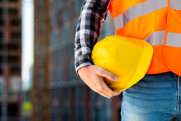Premium Photo | Close-up construction worker holding helmet
