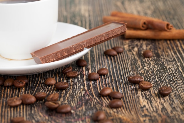 コーヒーとココアのお菓子で作ったデザート ココアと砂糖で作った甘いチョコレートとホットコーヒー コーヒーとマグカップとミルクチョコレートをクローズアップ プレミアム写真