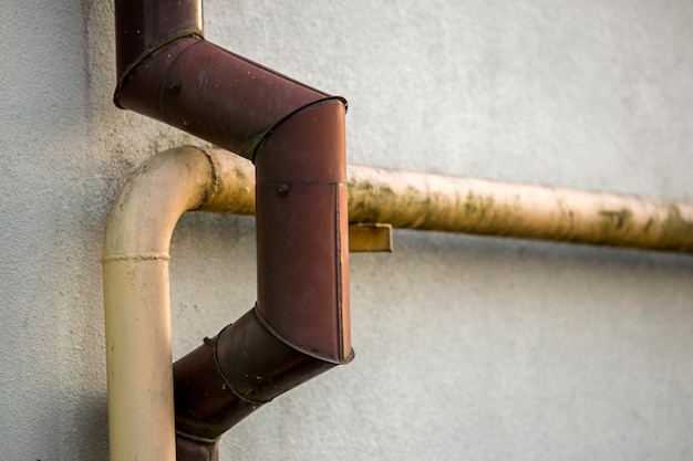 Premium Photo | Close-up detail of old dirty painted yellow natural gas and  brown gutter rain water pipes