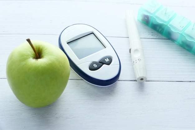 Premium Photo | Close up of diabetic measurement tools, apple and ...